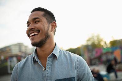 portrait laughing young man in park Image of a man laughing and standing in a park