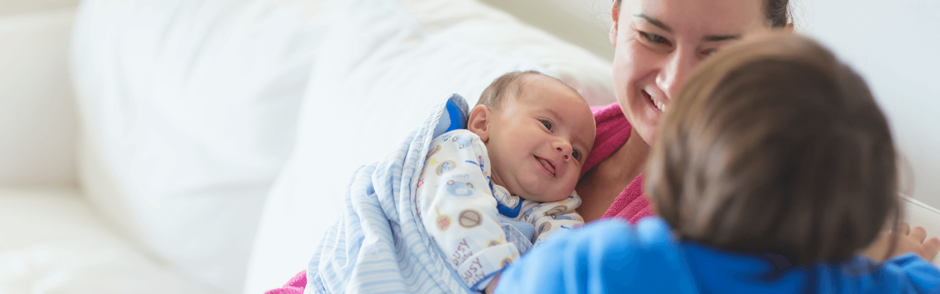 mom-holding-infant-smiling-at-toddler mom-holding-infant-smiling-at-toddler