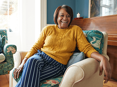 cheerful-woman-sitting-livingroom cheerful-woman-sitting-livingroom