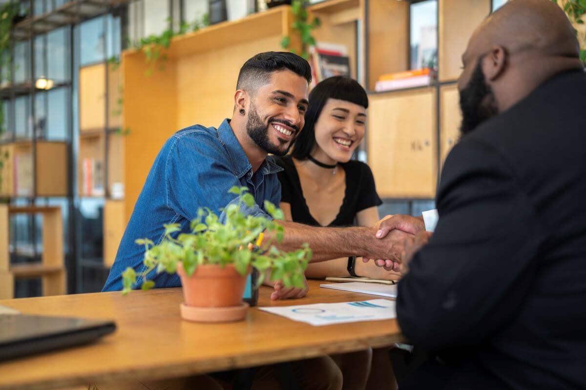 young-couple-shaking-hands-with-advisor young-couple-shaking-hands-with-advisor