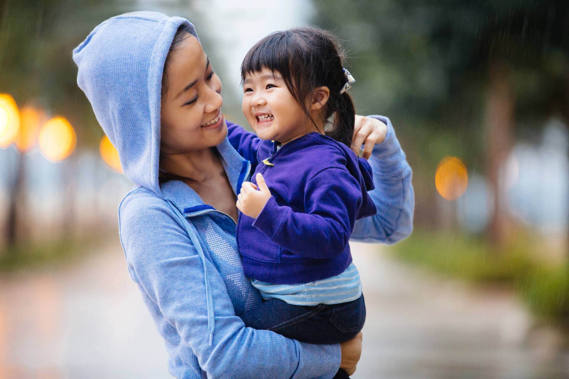 Mom in blue hooded shirt holds child