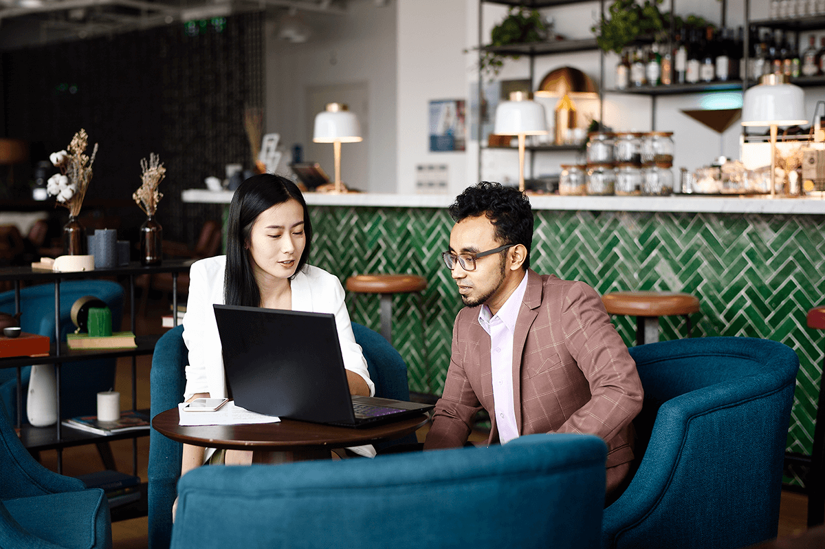 man-and-woman-looking-at-computer-in-coffee-shop man-and-woman-looking-at-computer-in-coffee-shop