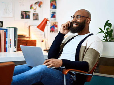 man-smilining-on-cell-phone-on-home-office man-smilining-on-cell-phone-on-home-office