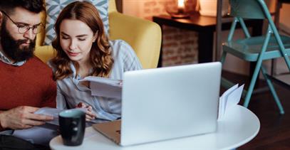 young-couple-reviewing-paperwork-on-living-room